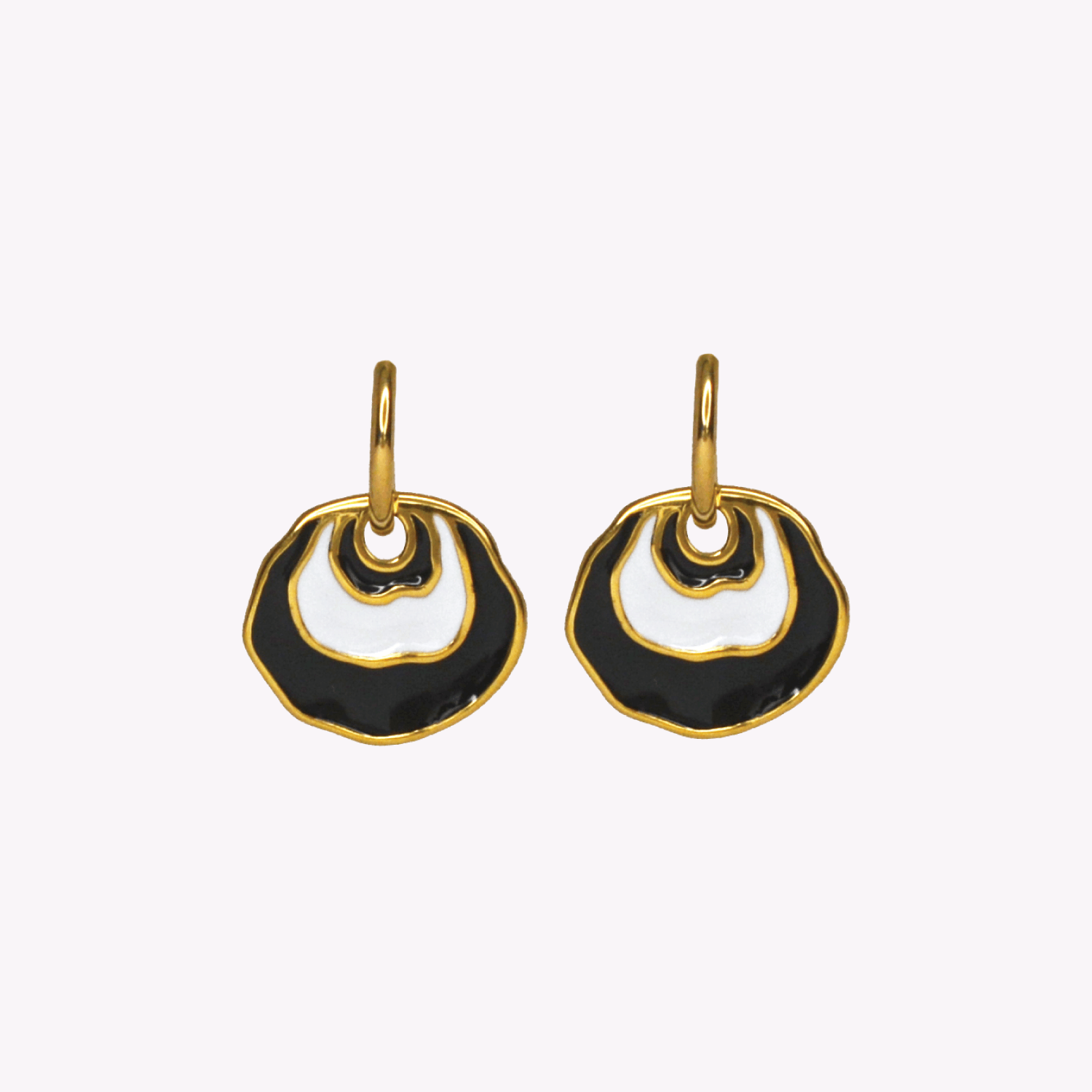 A pair of gold-tone dangle earrings with organic, wavy openwork circular shapes filled with black and white enamel, shown against a plain off-white background. Inspired by a Jingle seashell.