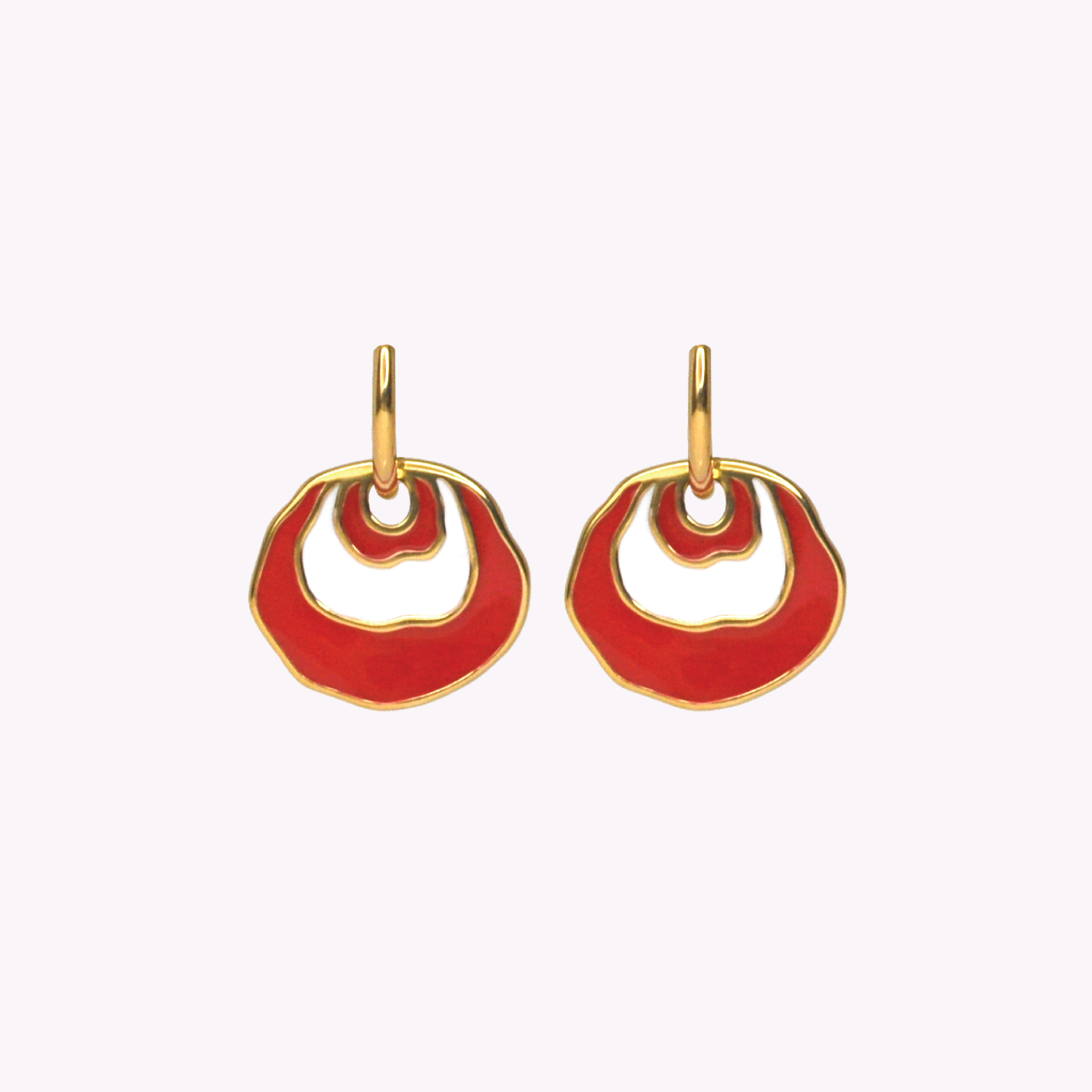 A pair of gold hoop earrings with a white and red concentric dangle design.  Irregularly shaped earrings on a plain light background.